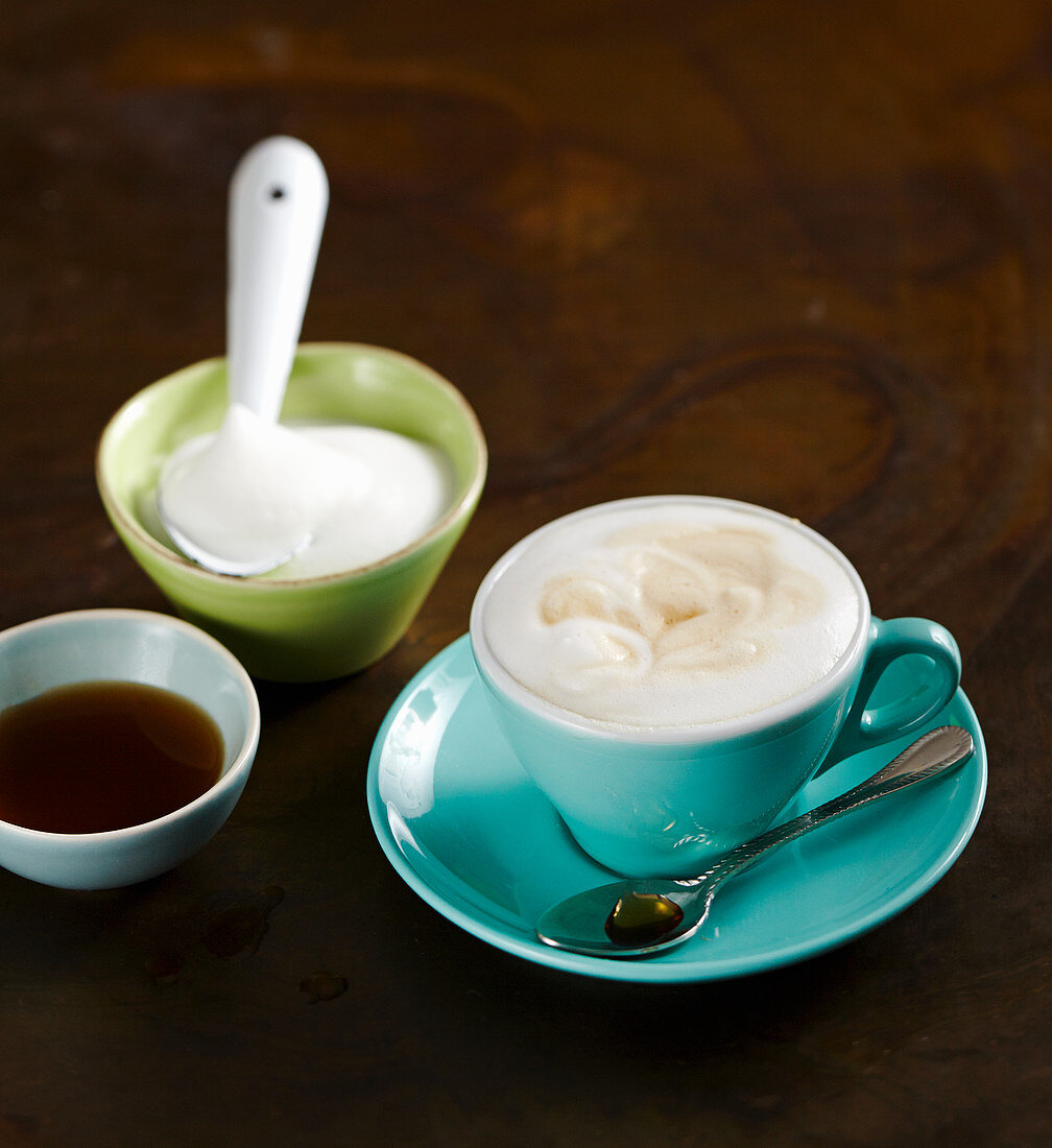 Eine Tasse heisse Milch mit Milchschaum und Chai-Sirup