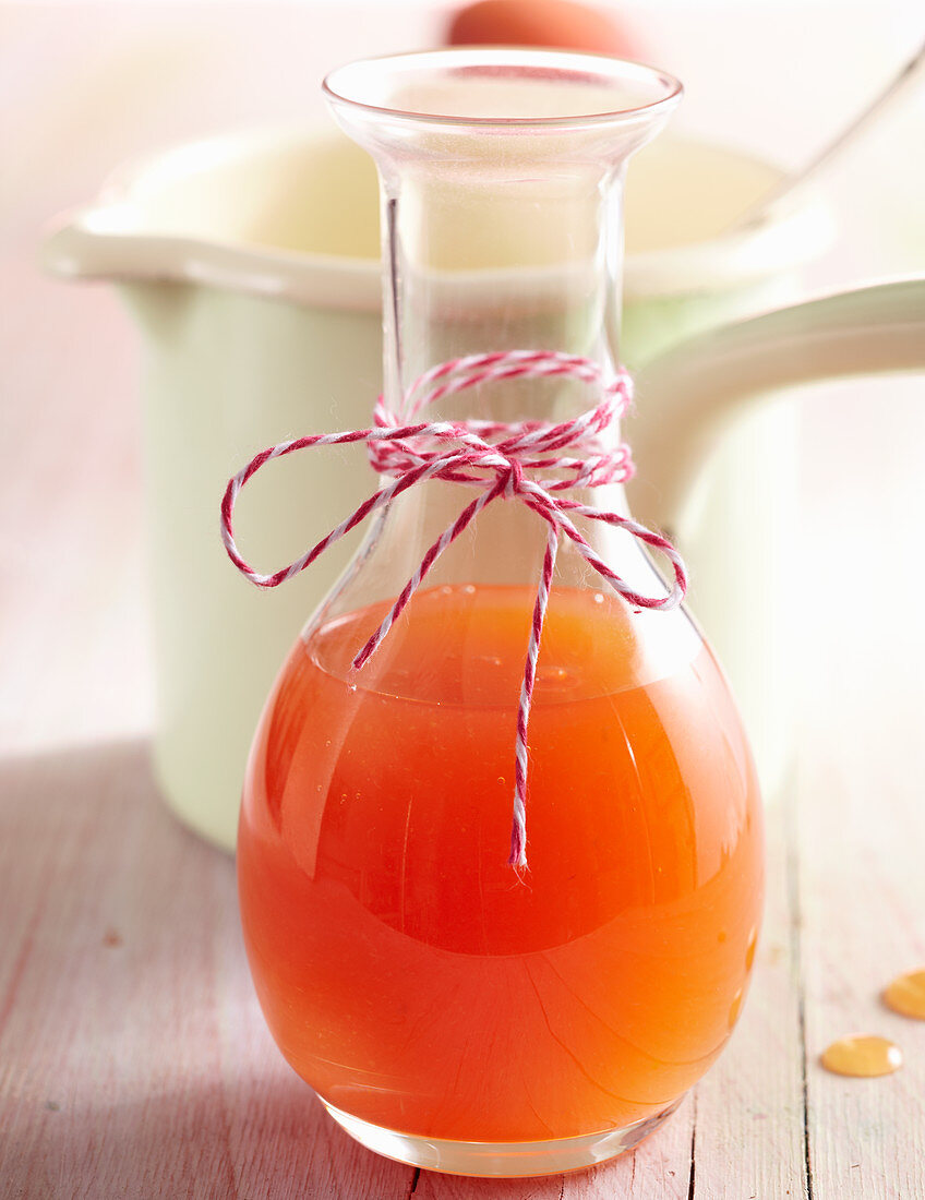 Summery homemade peach syrup in a carafe