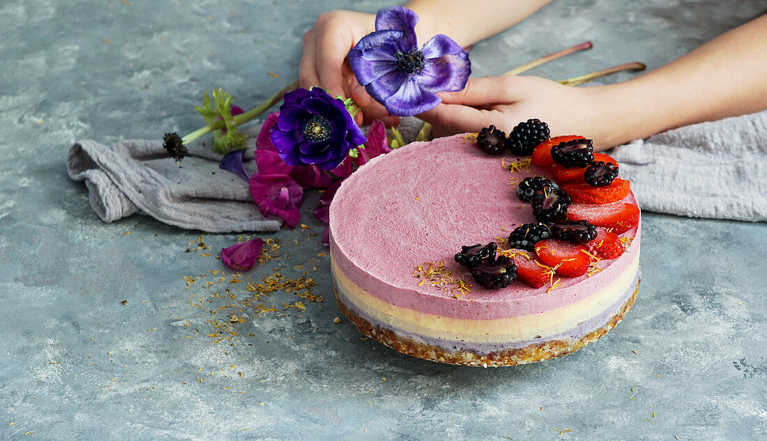 Veganer roher Cashewkuchen mit Beeren, Kokosbutter, Kokosmilch und Mandel-Dattel-Boden