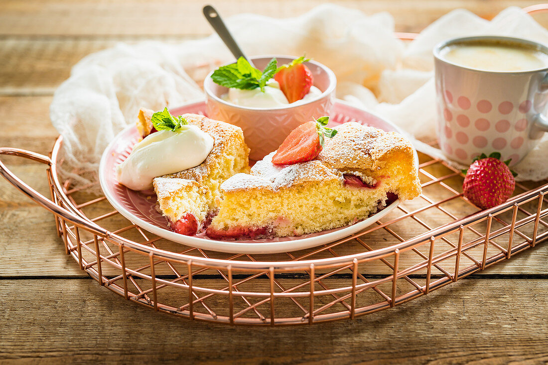 Simple and light sponge cake with fresh strawberries served with cream and mint