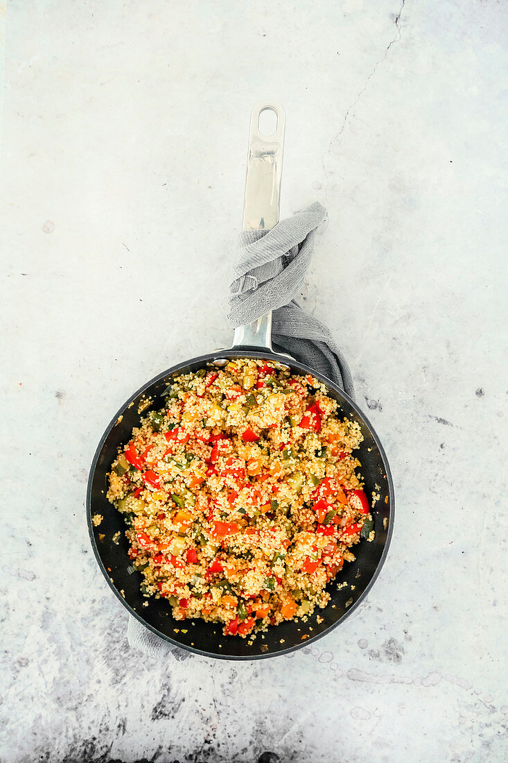 Couscous mit Paprika, Zucchini, Kirschtomaten, Zuckerschoten, Pinienkernen und Kräutern