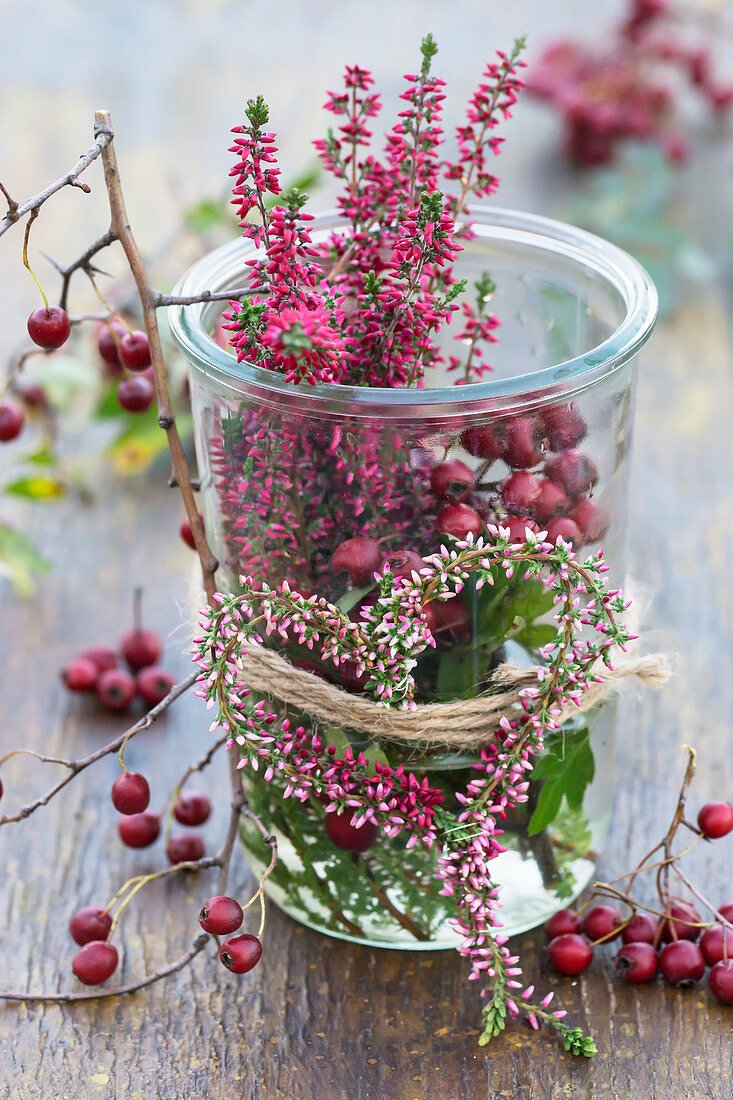 Preserving jar with budding heather in a heart shape and hawthorn berries