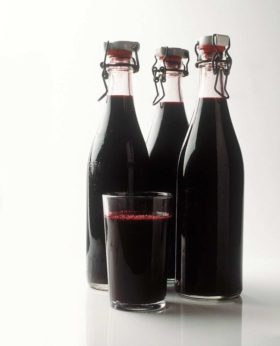 Elderberry juice in bottles and glass
