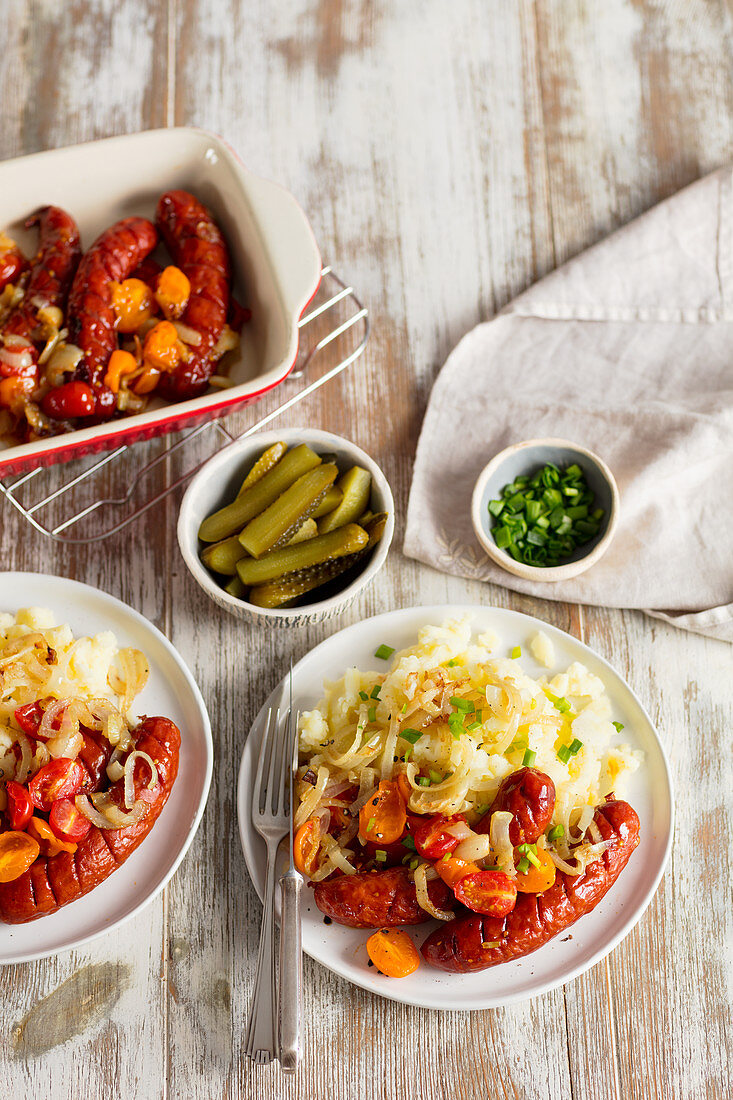 Bratwurst mit Zwiebeln, Kirschtomaten und Kartoffelpüree