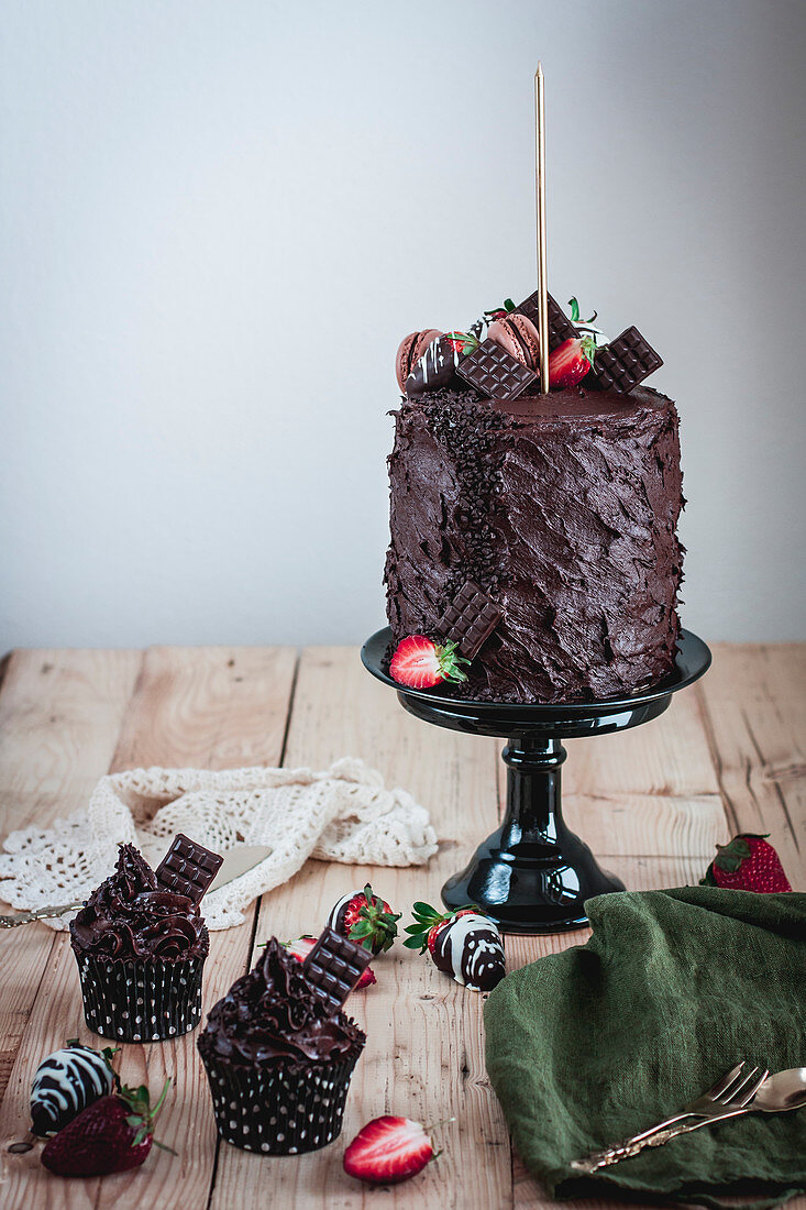 Geschichtete Schokoladen-Erdbeer-Torte und Cupcakes