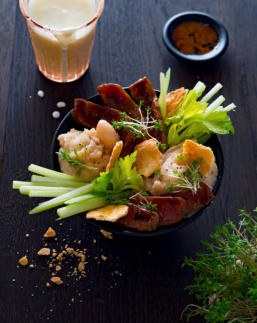 A bowl with tuna, bean purée, celery and crackers