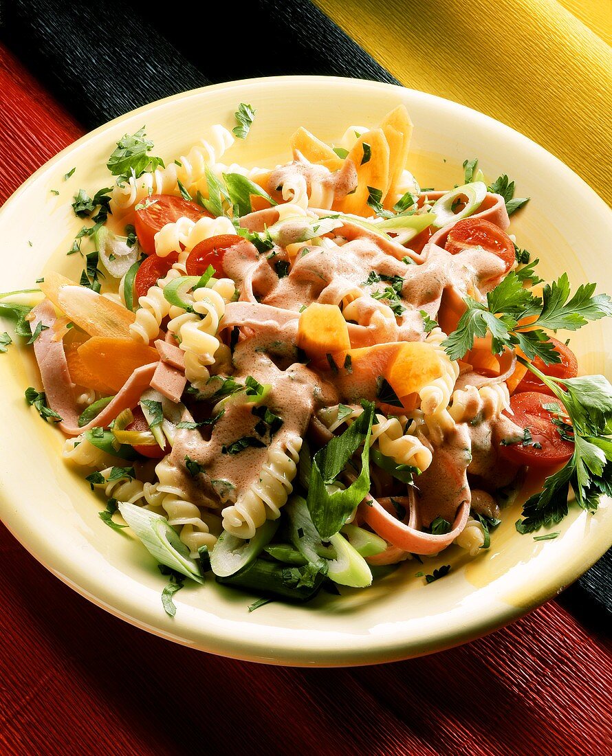 Spiralnudel-Gemüse-Salat mit Bierschinkenstreifen auf Teller