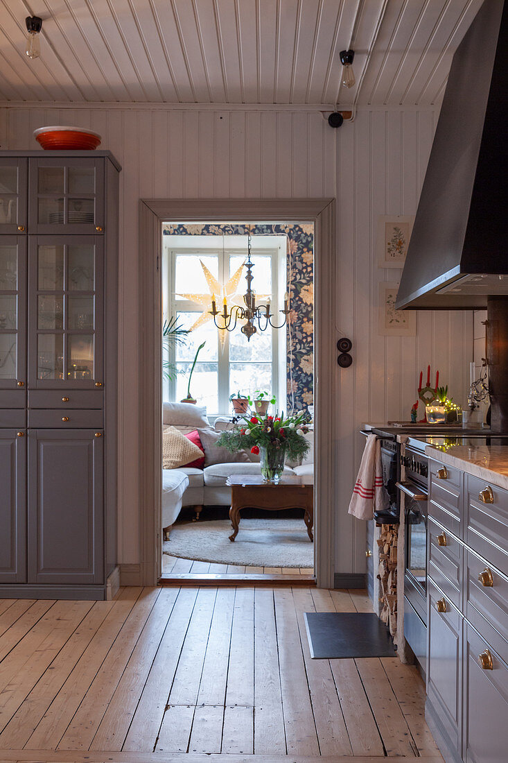Moderne Landhausküche mit taubenblauen Küchenschränken, Holzwänden und Dielenboden
