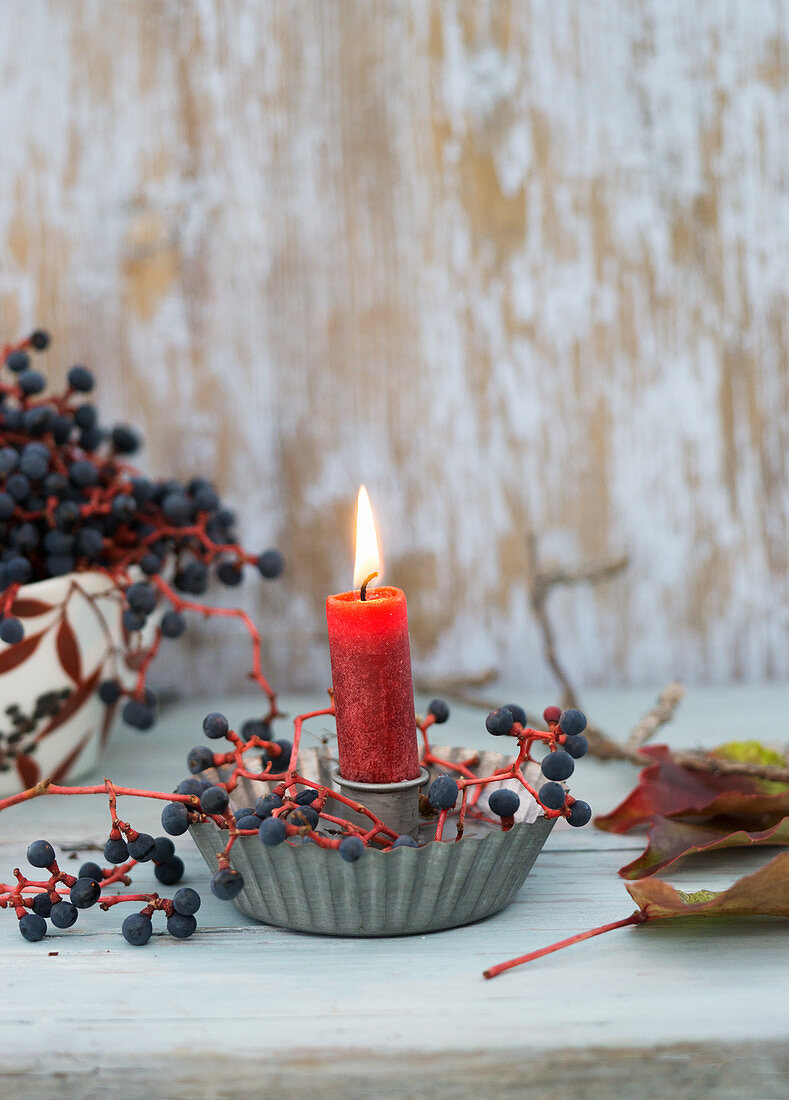Candle in holder made from cake tin and Virginia creeper berries