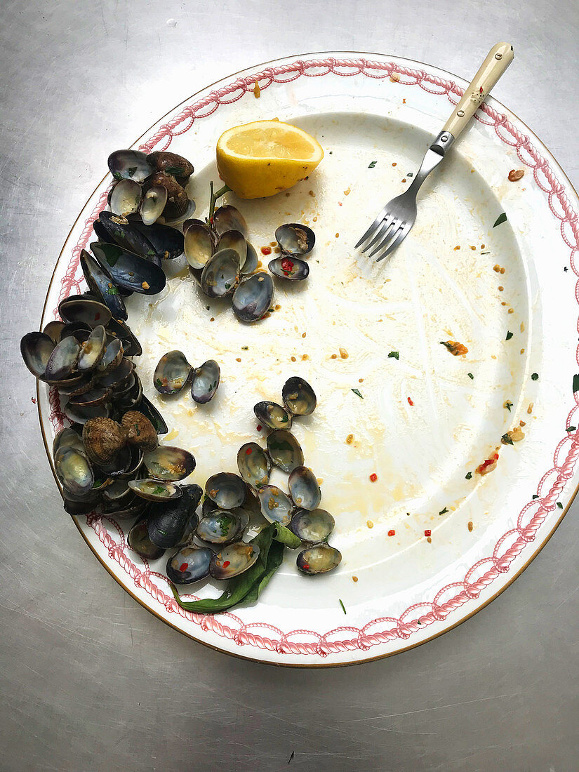 Mussel shells and a lemon on a plate