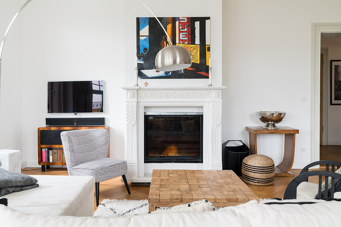 White chaise sofa and coffee table in front of fireplace in living room of period apartment