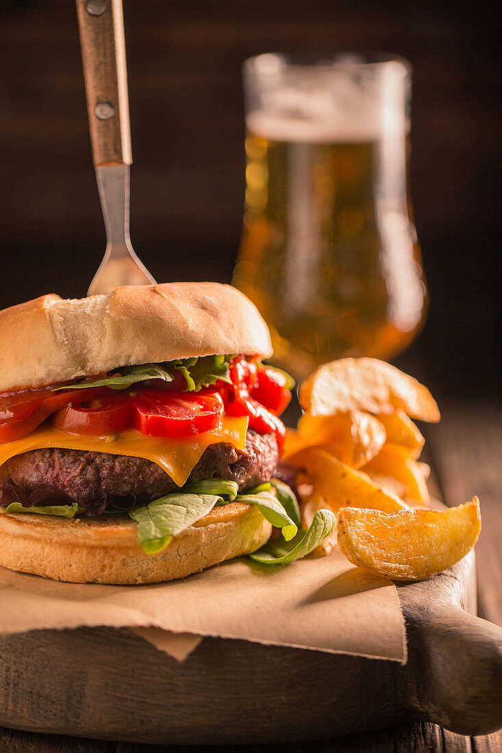 Hausgemachter Burger mit Käse, Salat, Tomate und Essiggurken