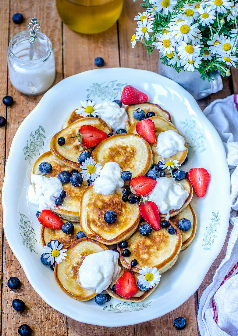 Pancakes with yogurt, honey, strawberries and blueberries