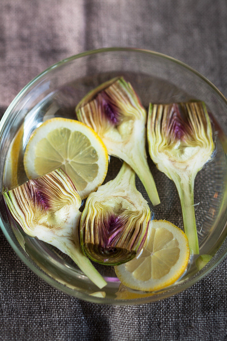 Halved artichokes in lemon water