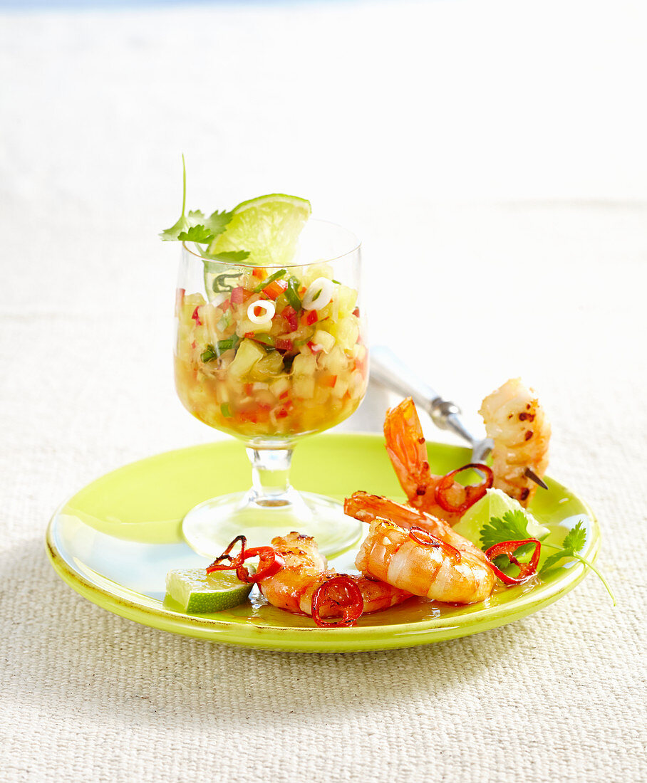 Pineapple salsa with fried prawns on a green plate