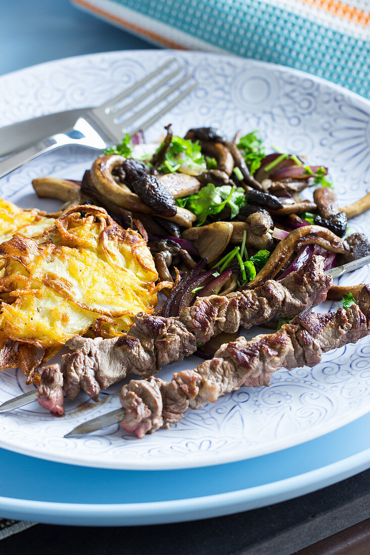 Pioppini mushrooms with lamb skewers and potato pancakes