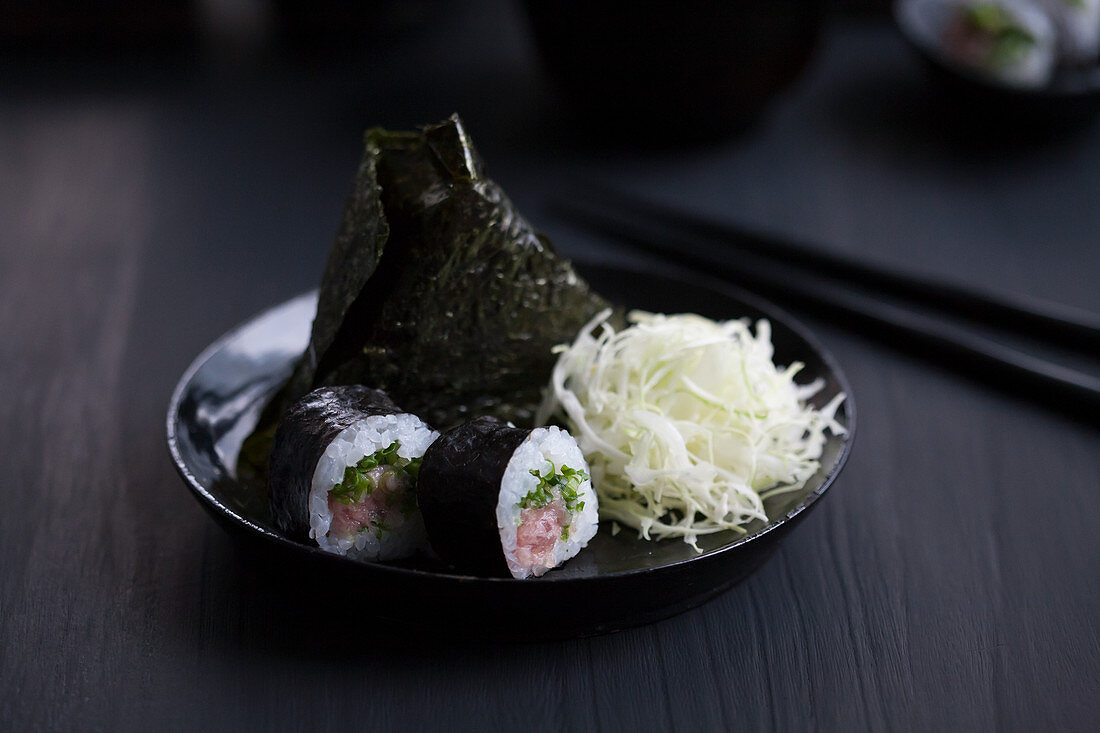 Onigiri und Maki-Sushi mit Thunfisch dazu mit Dashi gewürzter Kohl (Japan)