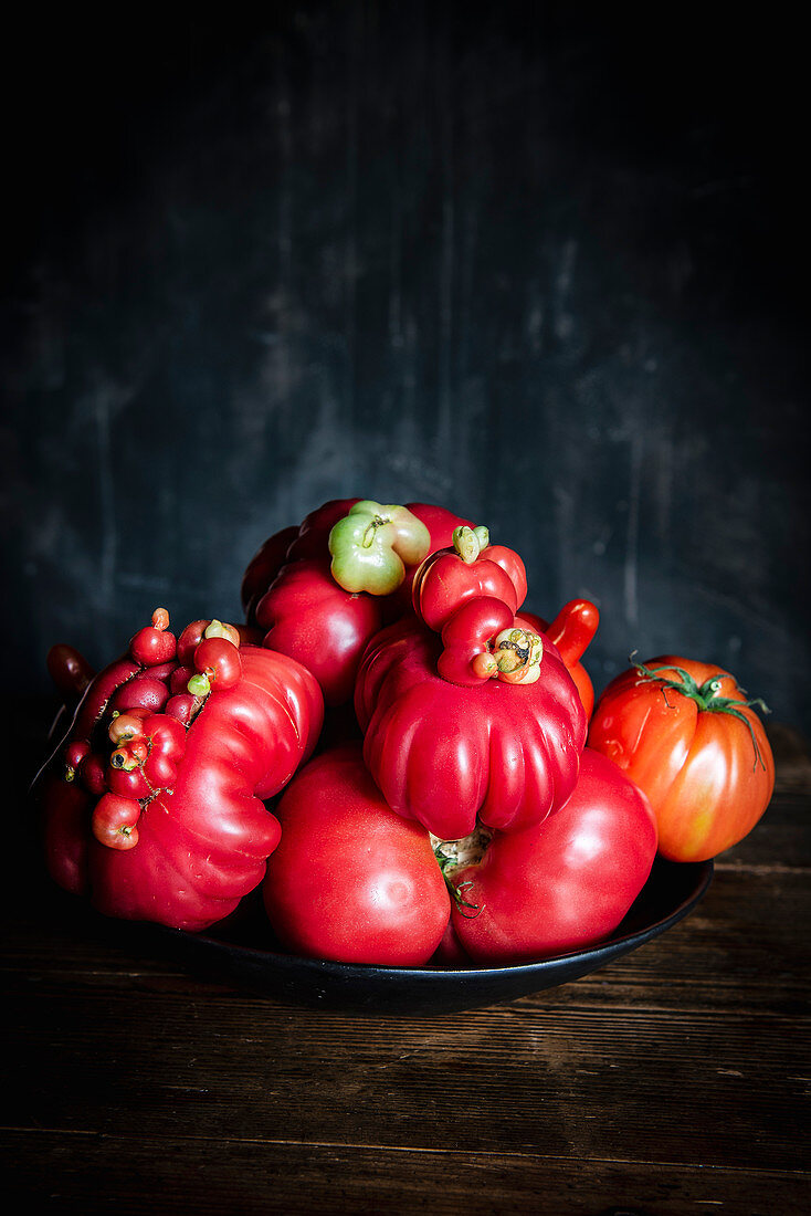 Verschiedene Tomaten auf schwarzem Teller