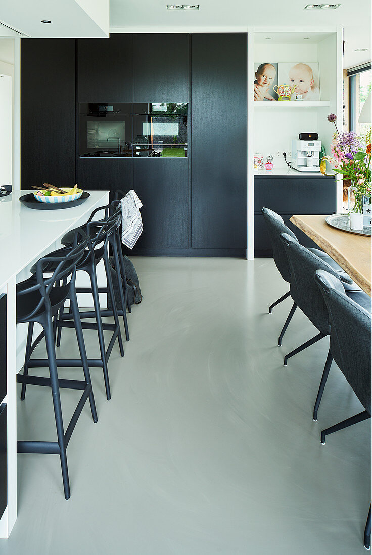 Breakfast bar and dining table in open-plan kitchen area in black and white