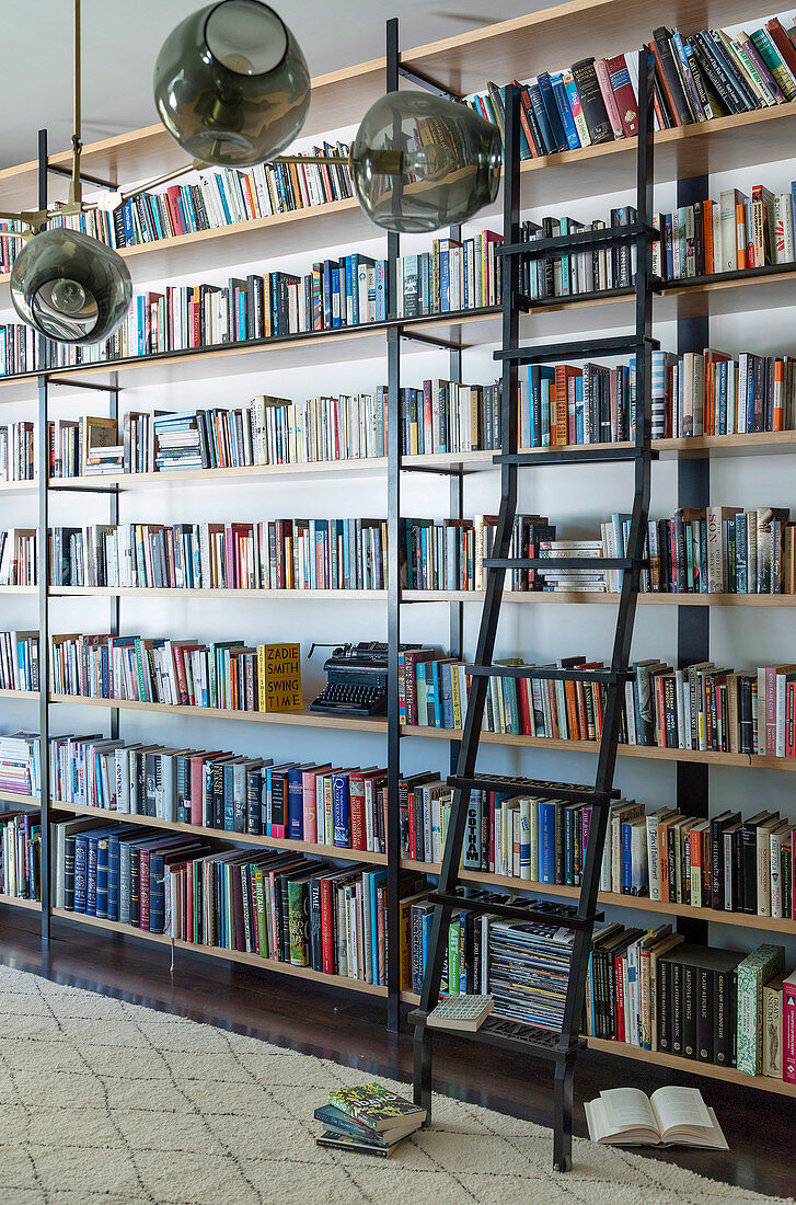 Ceiling-high bookshelves with sliding shelf ladder