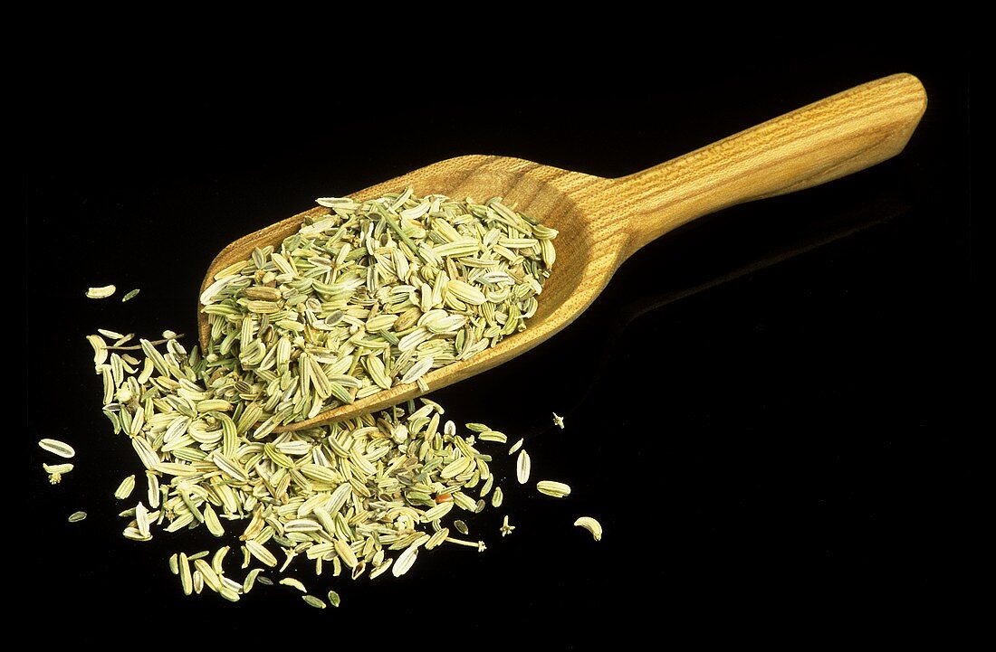 Fennel Seeds Spilling From a Wooden Scoop