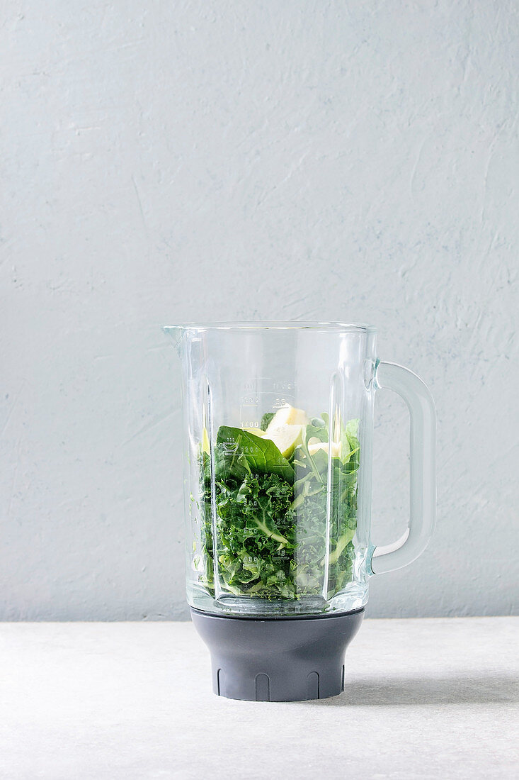 Zutaten für grünen Smoothie mit Spinat, Kohl und Apfel im Blender