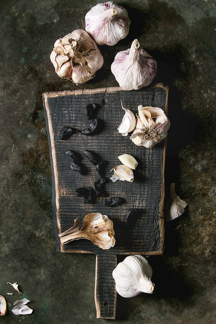 Variety of fresh organic garlic bulbs whole and peeled and cloves of black fermented garlic