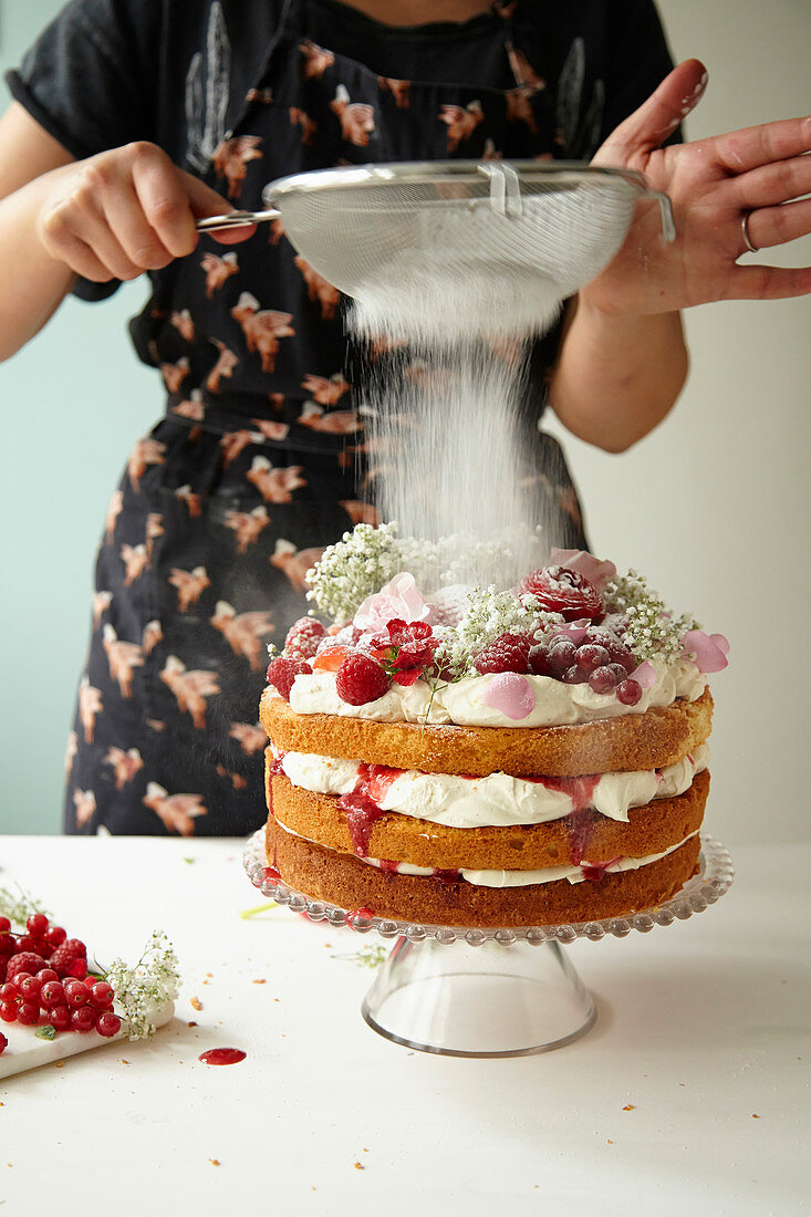Victoria Sponge Cake wird mit Puderzucker bestäubt