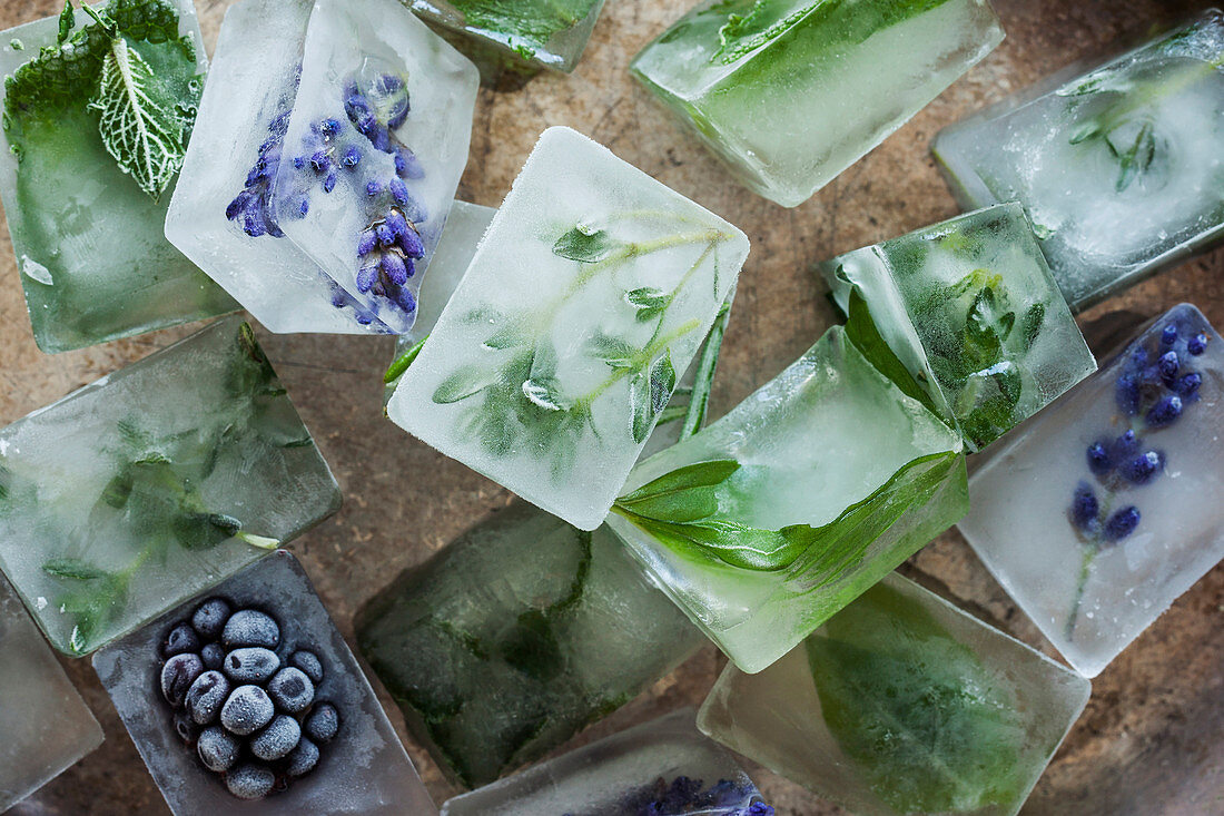 Homemade ice cubes with herbs, flowers and fruits