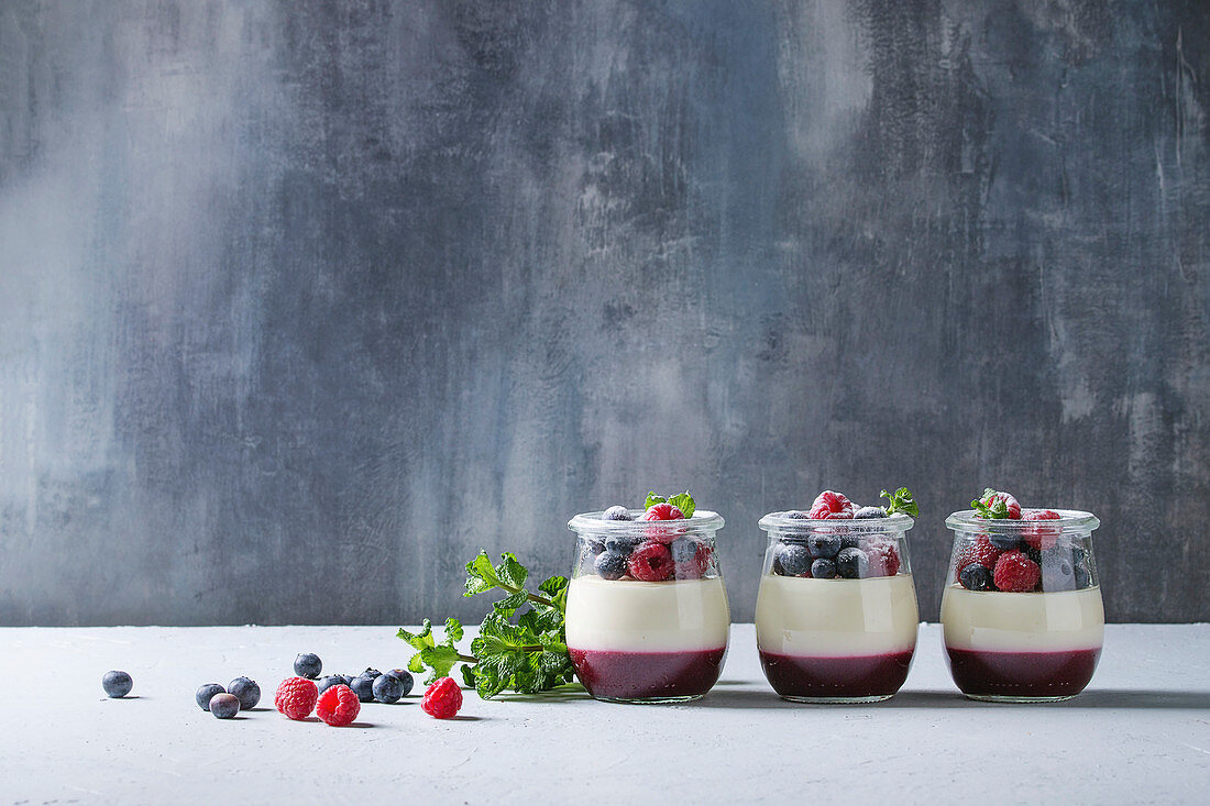 Homemade classic dessert Panna cotta with raspberry and blueberry berries and jelly in jars