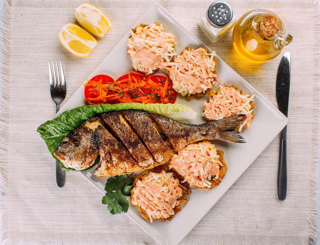 Gebratener Fisch mit Salat und frittierten Kochbananen