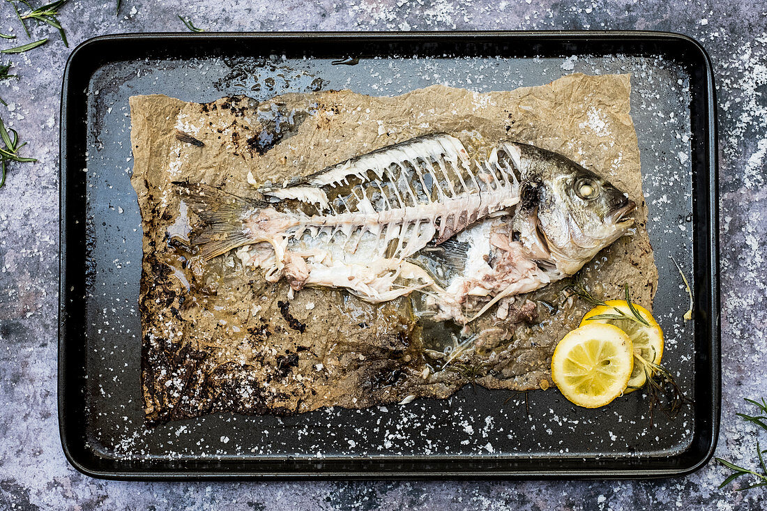 Skeleton of grilled sea bream on baking tray