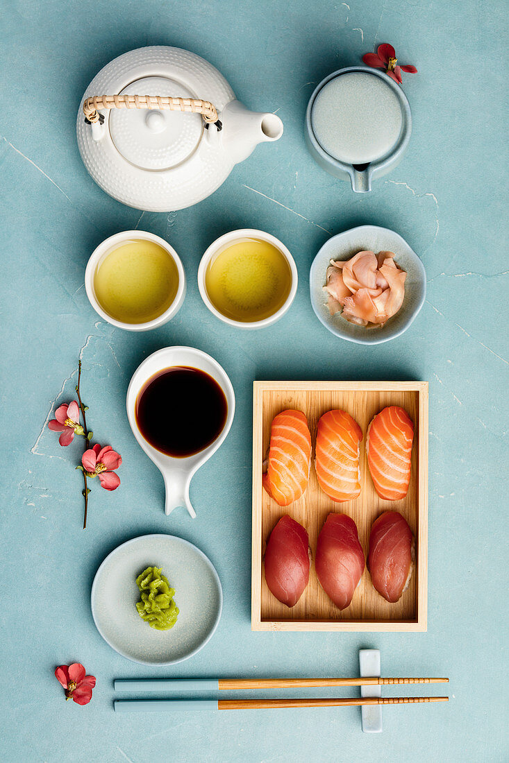 Nigiri-Sushi serviert mit Sojasauce, Ingwer, Wasabi und grünem Tee (Japan)