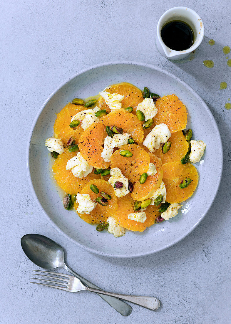 Savoury orange and bocconcini salad with a jug of spicy dressing