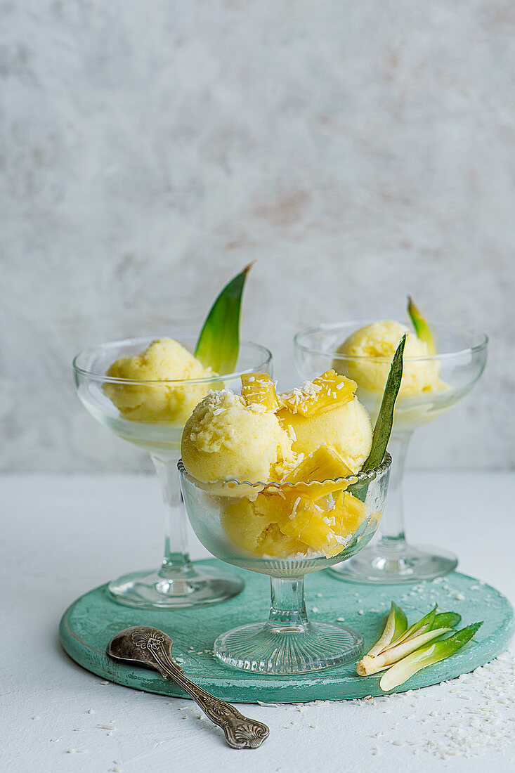 Pineapple and coconut sorbet with fresh pinaple pieces served in stem glasses