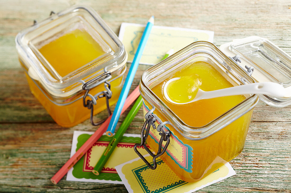 Yellow watermelon jelly with pineapple in a flip-top jar with coloured pencils