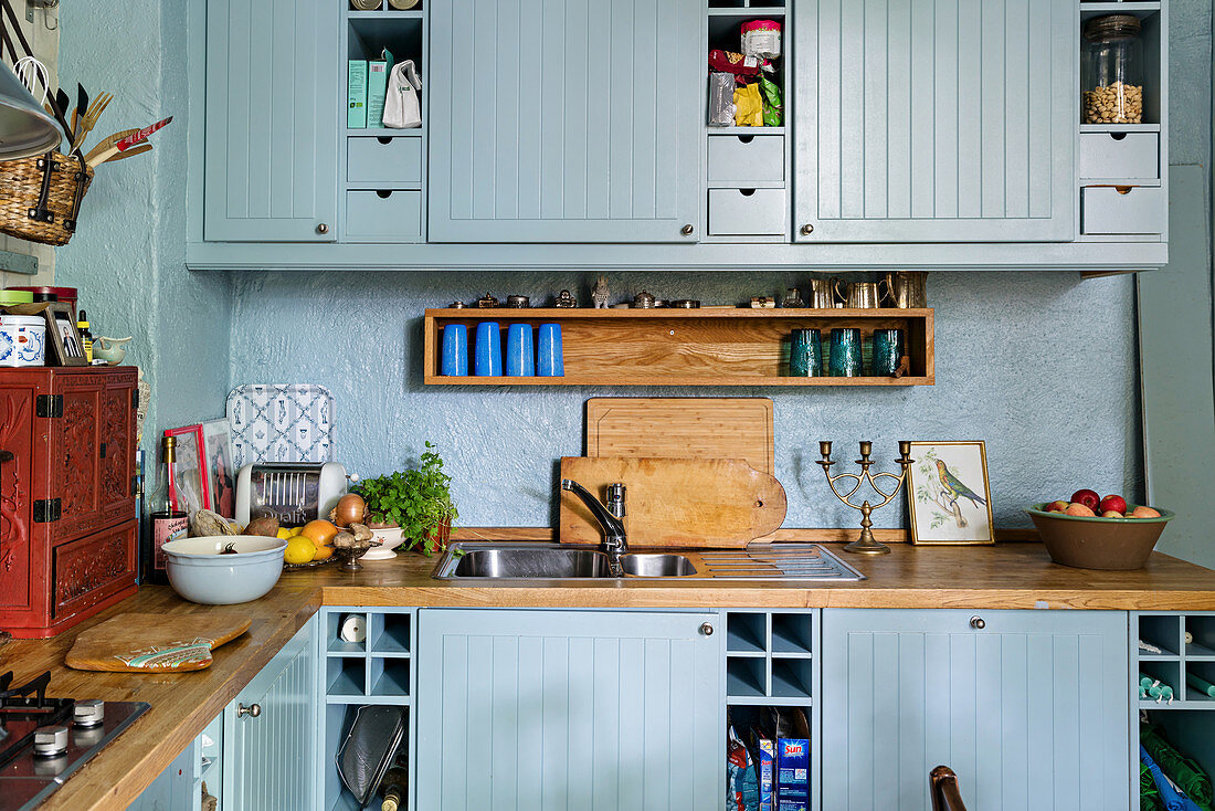Pale blue cupboards and wooden worktops in Bohemian-style kitchen
