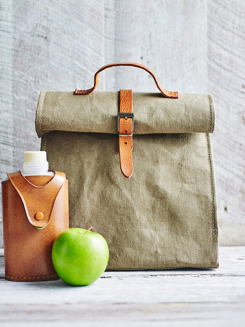 Lunchbag davor Trinkflasche und Apfel
