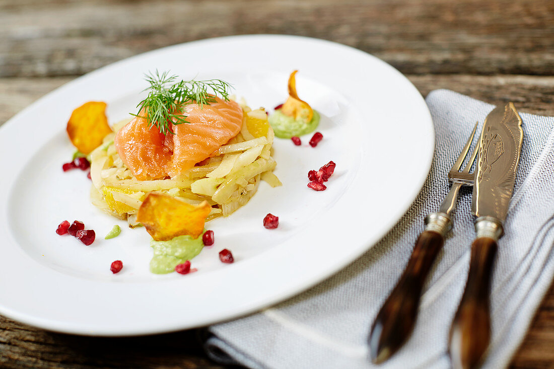 Räucherlachs auf Fenchel mit Orangen, Granatapfelkernen, Kartoffelchips und Dill