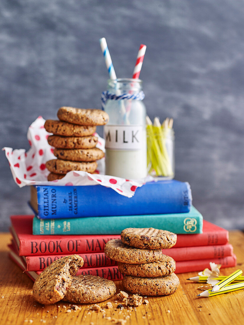 Kakao-Haselnuss-Plätzchen und Milch auf Bücherstapel