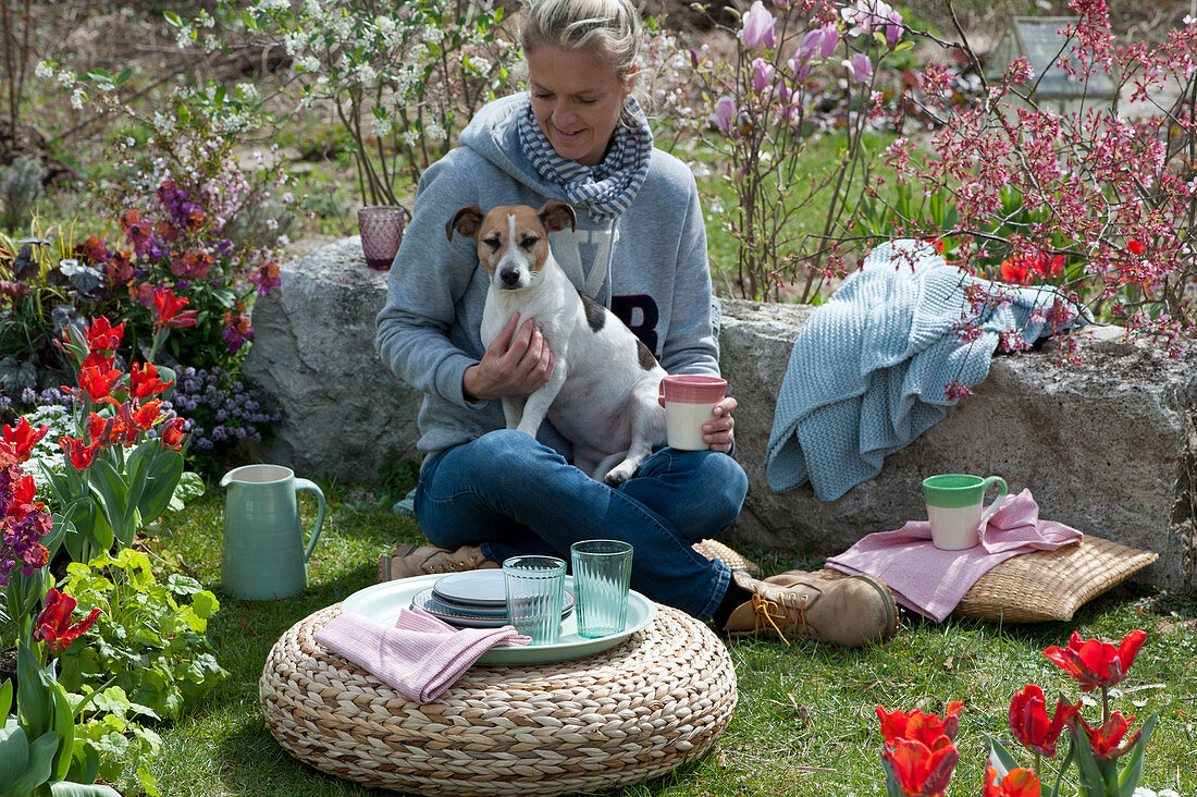 Woman with dog Zula enjoys the spring garden