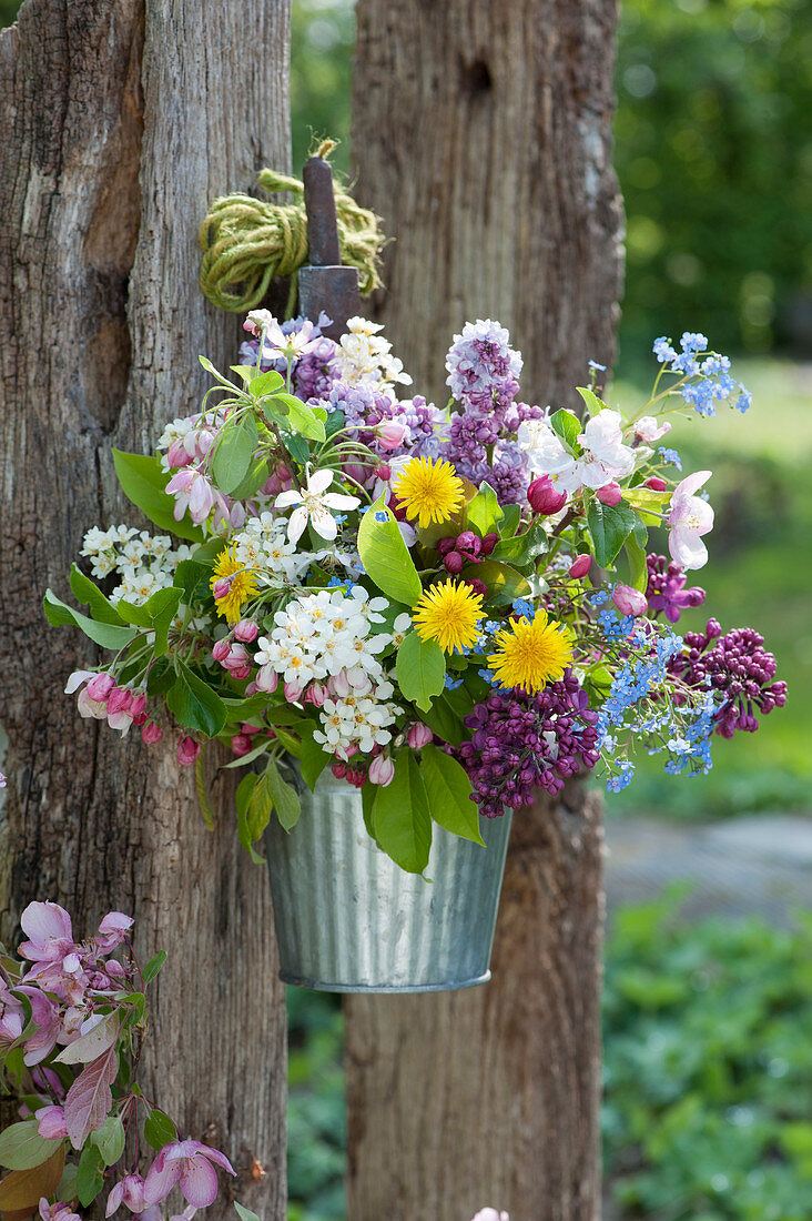 Colourful spring bouquet of lilac, apple blossoms, bird cherry, dandelions and commemorative