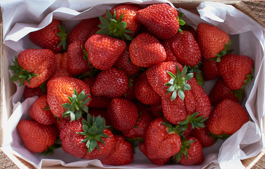 Fresh strawberries in a wooden crate