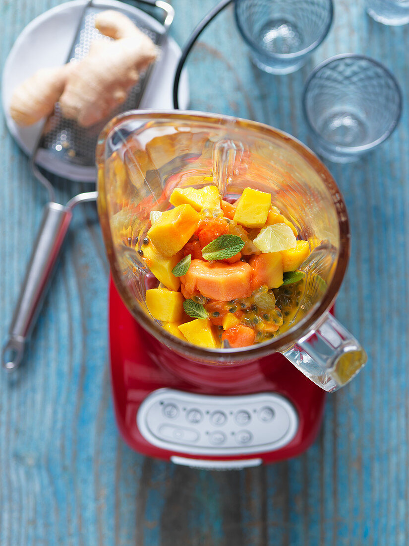 Zutaten für Smoothie (Mango, Papaya, Passionsfrucht) im Mixer