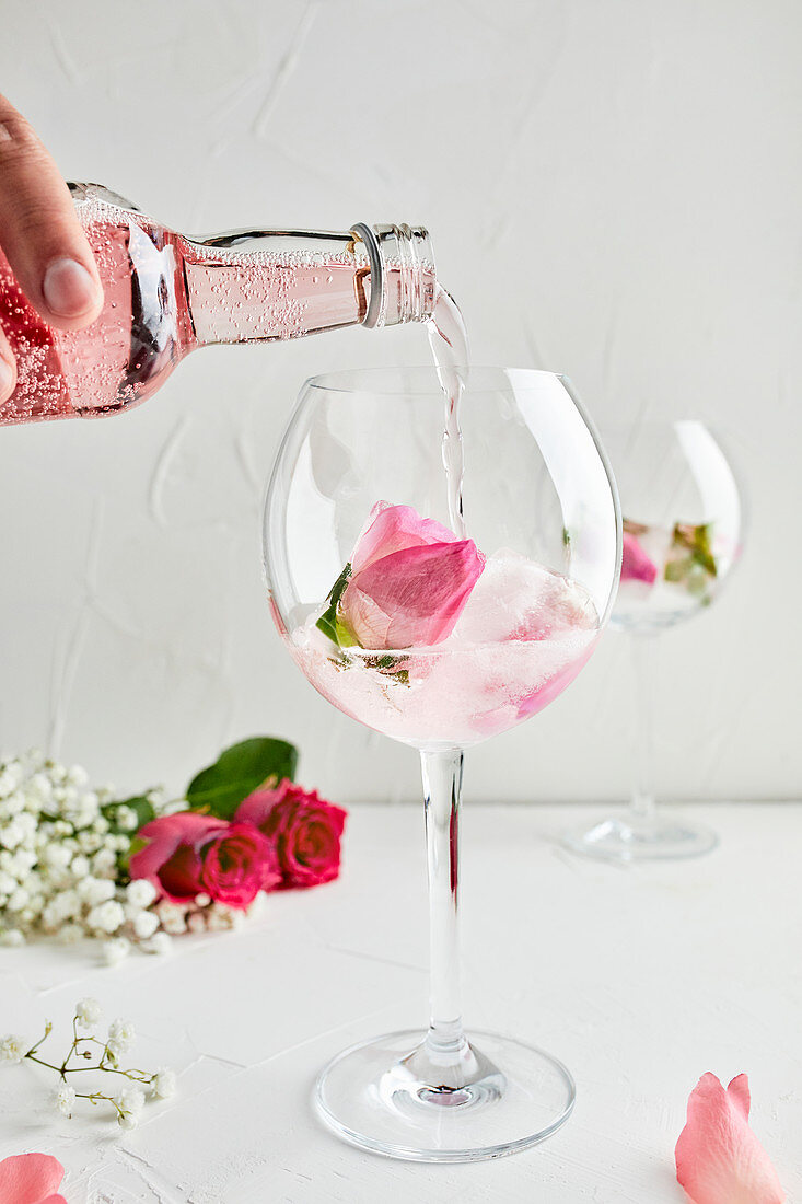 Pouring rose infused tonic for the gin and tonic cocktail