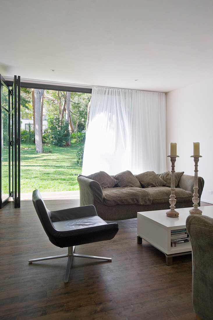 Simple living room with open terrace doors leading into garden