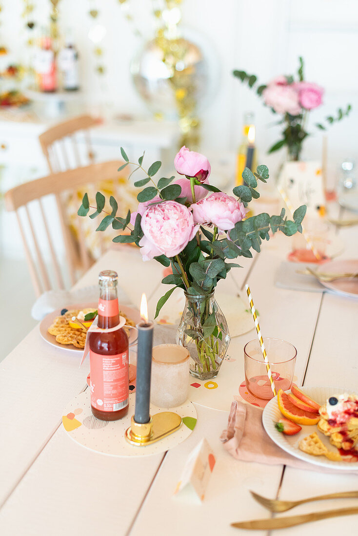 Table set with waffles and lemonade decorated with peonies