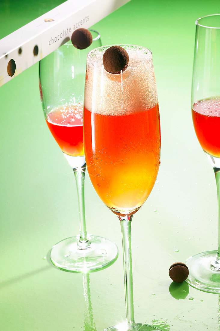 Moulin Rouge cocktails made with apricot brandy, gin, lemon juice, grenadine and champagne with chocolate pralines