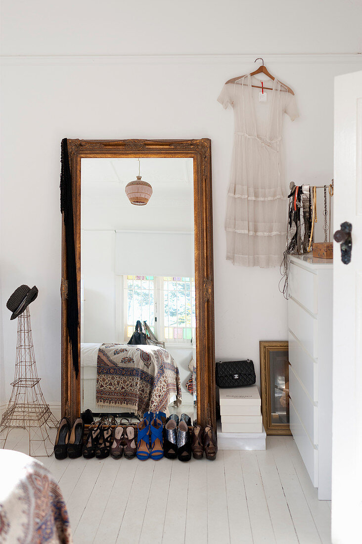 Ladies' shows in front of full-length mirror in white bedroom