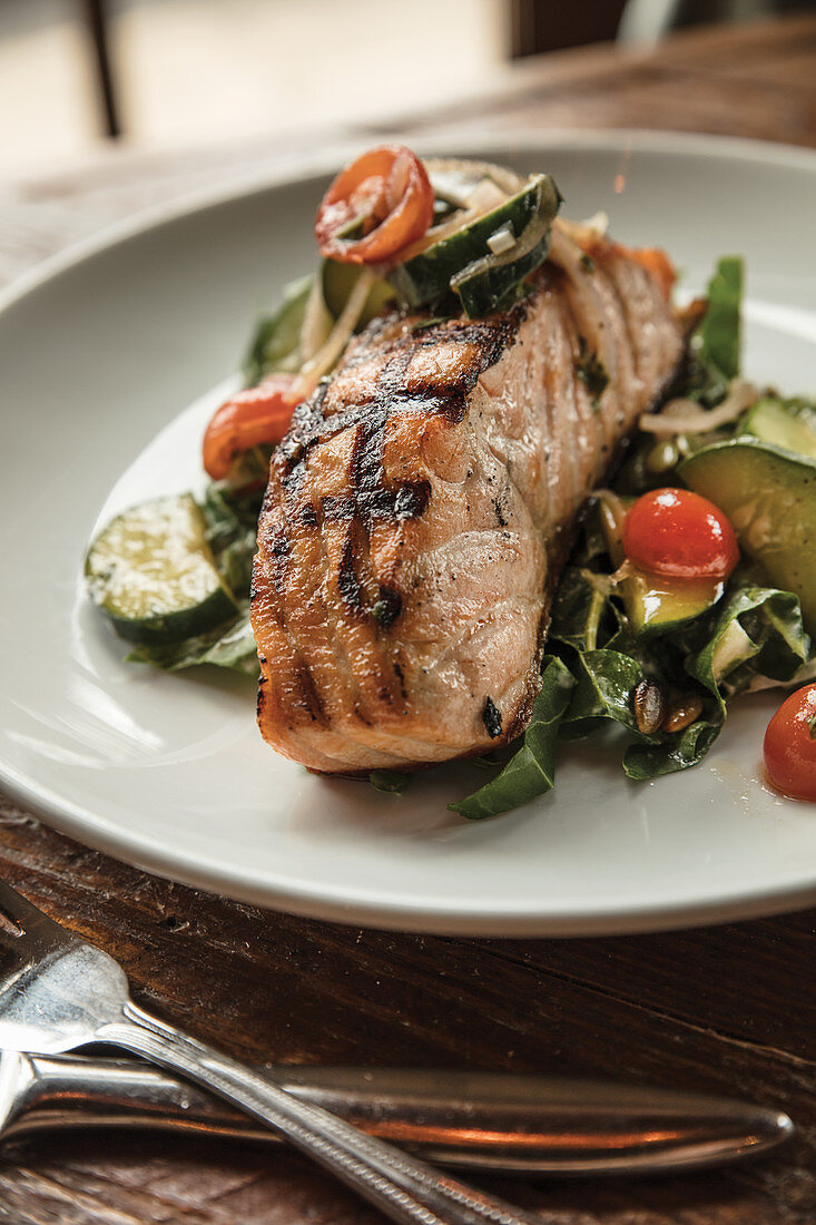 Woodfire-grilled salmon with Swiss chard and tahini salad, tomato and cucumber